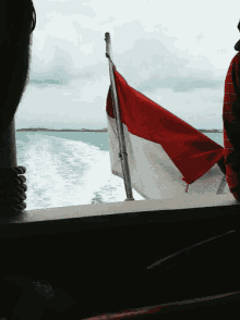 a red white and blue flag is flying over the ocean