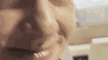 a close up of a person 's face with a blurred background .