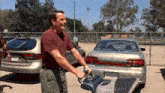 a man is standing in front of a silver car with a license plate that says 46u0623