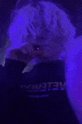 a person with blonde hair is wearing a black shirt that says ' aelemetv ' on it