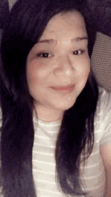 a close up of a woman 's face wearing a striped shirt and a cat ear hat .