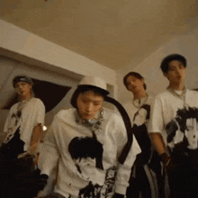 a group of young men are standing in a room dancing together .