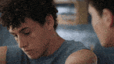 a man with curly hair is looking at his reflection in the mirror