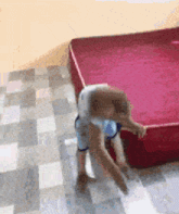 a child is crawling on a red mattress .