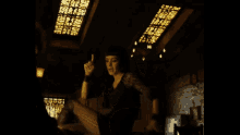 a woman in a black dress is giving the middle finger in a dark room