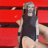 a person is holding a cardboard cutout of a man with long hair