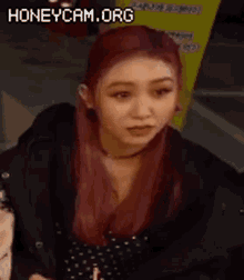 a woman with red hair is laughing while wearing a black jacket and polka dot dress .