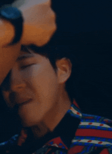 a man is touching another man 's face with his hand