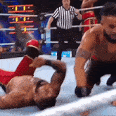 a wrestler is laying on the ground in a wrestling ring