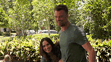 a man is giving a woman a piggyback ride in the park .