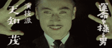 a man in a suit and tie has chinese writing on his hands