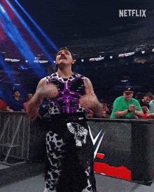 a wrestler flexes his muscles in front of a crowd and a sign that says netflix
