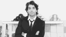 a man in a suit and tie with his arms crossed