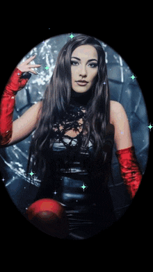 a woman in a black dress and red gloves is in a circle