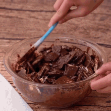 a person is mixing chocolate in a glass bowl