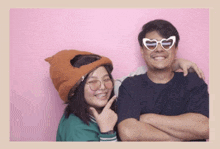 a man and a woman wearing heart shaped sunglasses and a hat