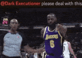 a basketball player wearing a lakers jersey is pointing at the referee