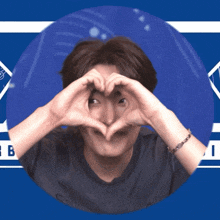 a man making a heart shape with his hands in front of his eyes