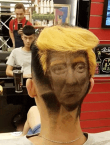 a man in a barber shop has a picture of donald trump on his hair