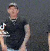 a man wearing a hat and a necklace is dancing .