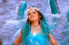 a woman in a blue dress is standing in a body of water .