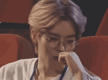 a close up of a person wearing glasses and a white shirt