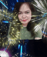 a woman in a green shirt is surrounded by fireworks and sparkles