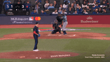 a baseball game is being played in front of an ad for budweiser