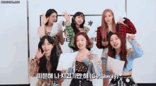 a group of girls are posing for a picture and one of them is holding a piece of paper that says get away