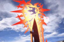 a red and yellow sculpture with a blue sky in the background