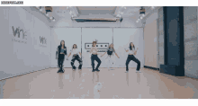 a group of girls are dancing in front of a wall that says wne