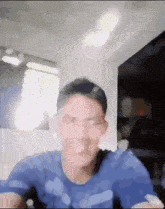 a man wearing a blue shirt is making a funny face