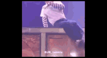 a man in a white shirt and blue pants is standing on a box on a stage .