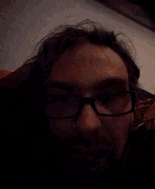 a man wearing glasses and a beard is looking at the camera