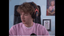 a young man wearing headphones is sitting in a chair in front of a computer .