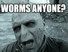 a black and white photo of voldemort from harry potter with the words `` worms anyone ? '' on his face .