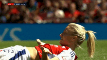 a female soccer player is laying on the field during a game between arg and mnu