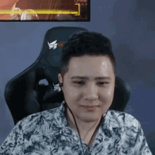 a man wearing headphones is sitting in a gaming chair .
