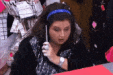 a woman wearing a watch and a headband is talking on a phone