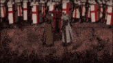 a man in a red coat stands in front of a row of soldiers with shields that have the letter h on them
