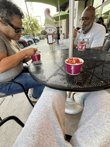 a man wearing a black shirt is eating ice cream