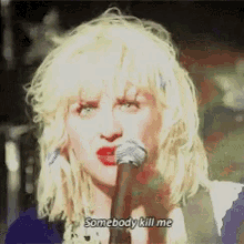 a woman singing into a microphone with the words " somebody kill me " above her