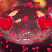 a close up of a frog with red hearts around it
