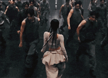 a woman in a white dress is surrounded by men