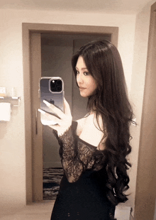 a woman taking a picture of herself in a bathroom mirror