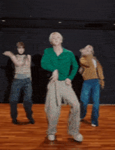 a group of people are dancing on a wooden floor in a studio .