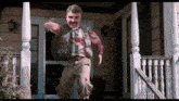 a man with a mustache is dancing in front of a porch