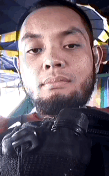 a man with a beard is holding a camera and looking at the camera