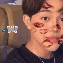 a young man with lipstick kisses on his face and the letter h behind him