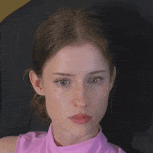 a woman in a pink shirt with her mouth open